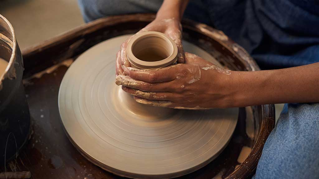 A student beginning a wheel-thrown project